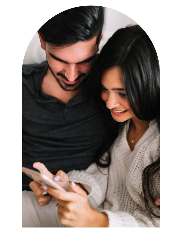 Pareja mirando su invitación de matrimonio en el teléfono
